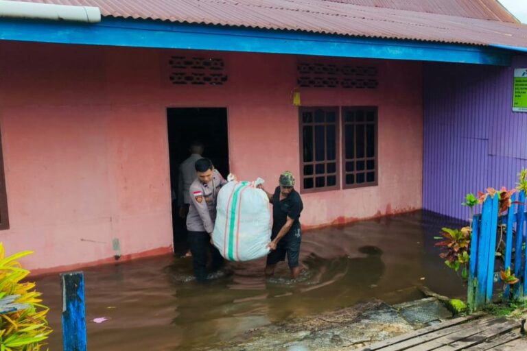 Teks Foto: Aparat kepolisian dibantu oleh TNI dan BPBD, saat melakukan evakuasi terhadap warga yang kebanjiran akibat intensitas hujan yang tinggi di ibu kota Keppi, Kabupaten Mappi, Provinsi Papua Selatan. (ist)