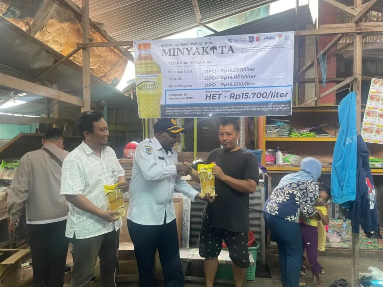 Teks Foto: Kadis Perindag Papua Selatan menyerahkan minyak kita ke pedagang di Pasar Wanggu. (ist)