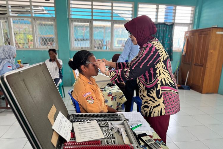 Teks Foto: dr. Sri Wahyuti, Sp.M melakukan pemerisaan mata kepada seorang siswa SMPN 4 Nabire. (ist)