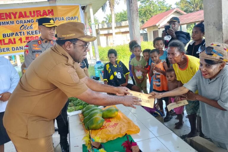 Teks Foto: Bupati Keerom Piter Gusbager saat menyerahkan bantuan dana paket UKMK. (ist)