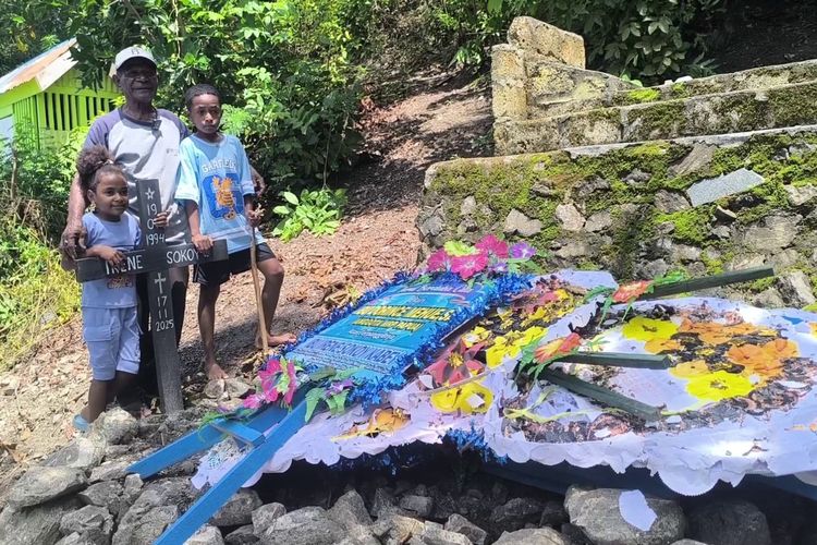 Teks Foto: Abraham Kabey dan kedua cucu (anak Irene Sokoy) saat berdiri di makam Irene Sokoy. (ist)